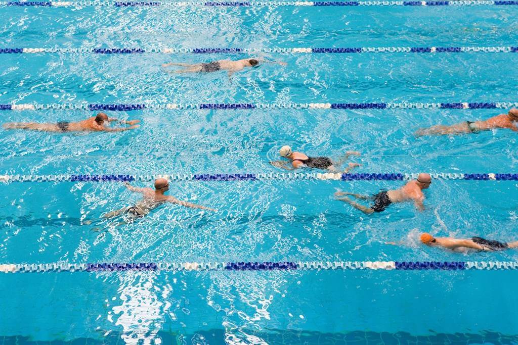 Woman enjoying aqua aerobics class in a pool with water splashing